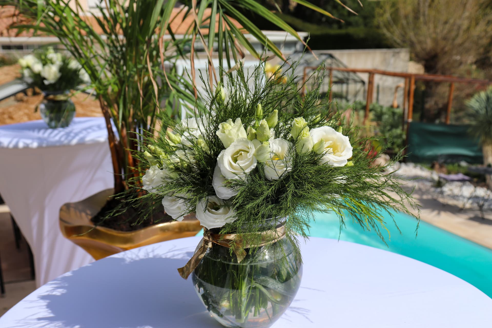 Scénographie florale d'un événement d'entreprise avec fleurs en papier roses et arches végétales vert sauge